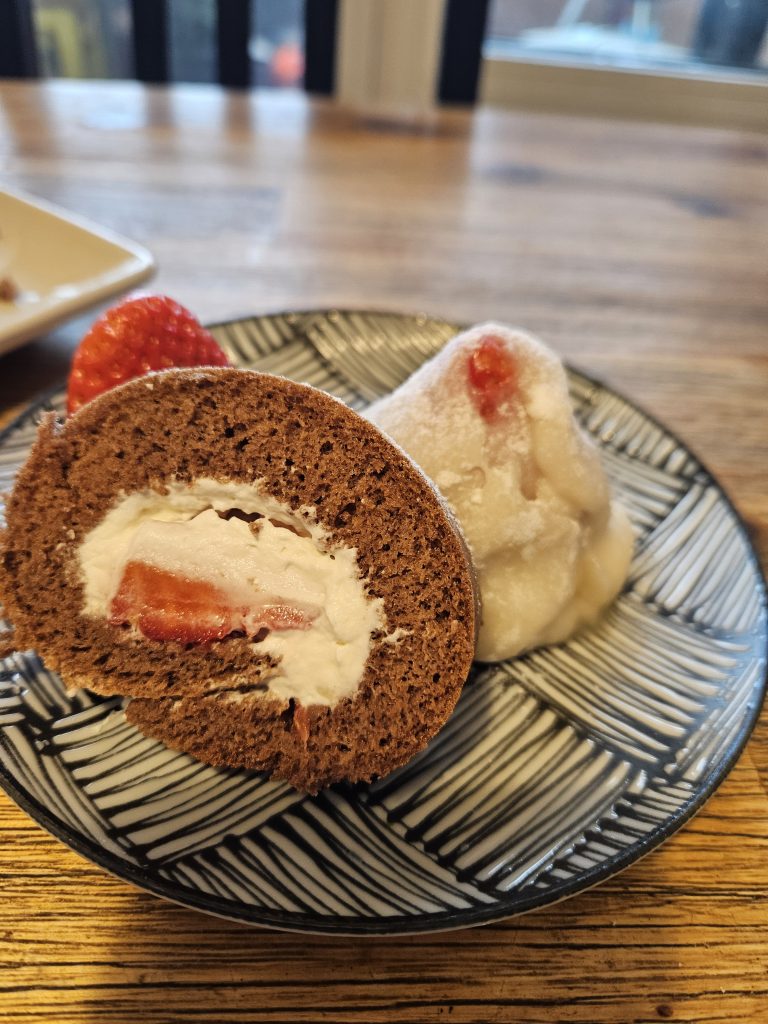 „Schoko-Erdbeer-Rolle zusammen mit einem Erdbeer-Daifuku auf einem Teller, selbstgemachte japanische Süßigkeiten“